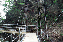 田立の滝登山道吊橋（新設工事）・長野県木曽郡南木曽町田立地内駐車場から約1時間歩いた当たり。霧ヶ滝の西側。急な階段を上ったところ。　主索を斜索に分散させ、1本当たりにかかる荷重を600kg以下に設計。設計積雪量250cm。　麓方面に向かって。
